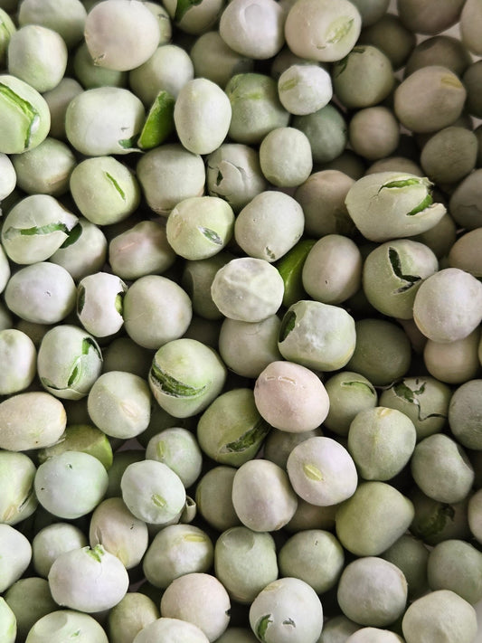 A close-up of Bulk Freeze-Dried Peas from I Heart Bugs, showing their round, pale green shape. Some are cracked, revealing texture—ideal isopod food—tightly packed and filling the frame.