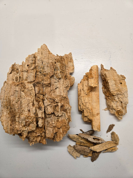 A close-up photo shows pieces of Wood Rot (Decaying Wood) from I Heart Bugs scattered on a light gray surface. The largest jagged chunk and smaller fragments reveal textures perfect for use as isopod substrate. Quart bag size shown.