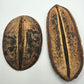 Two large I Heart Bugs Para Para Pods, known as aquarium botanicals and terrarium decor, rest on a white background. The left pod is shorter and rounder with dark spots; the right is longer and evenly colored.