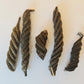 Five Fusilli Twisty Pods from I Heart Bugs are arranged on a white background. Each spiral-shaped pod varies slightly in length and thickness, featuring textured surfaces and pointed tips—making them a striking addition to natural aquarium decor.